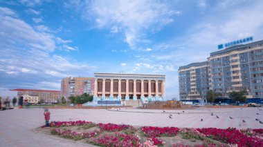 Kazakistan 'ın Atyrau şehrindeki Makhambet Utemissov Tiyatrosu' ndan Timelapse Hyperlapse. Güneşli bir gün, Mavi Bulutlu Gökyüzüne karşı Kültürel Mücevheri gözler önüne seriyor