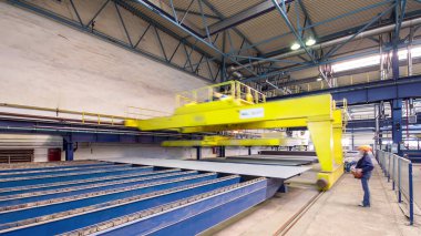 Factory workshop with yellow lifting crane device timelapse hyperlapse, lift loads using lifting magnet, mechanical workshop, metal structures plant. Automated machine for precise metal cutting.