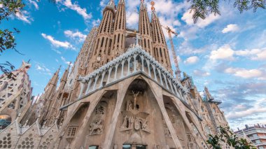 Sagrada Familia Timelapse Hyperlapse, Barcelona, İspanya 'da. Büyüleyici Sonbahar Sahnesi, Yeşil Ağaçlarla süslenmiş Mavi Bulutlu Gökyüzüne karşı