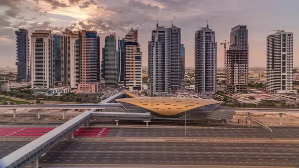 stock image Aerial view to Sheikh Zayed road during sunrise from Dubai Marina with JLT skyscrapers timelapse, Dubai. Traffic and metro station. Orange cloudy sky. United Arab Emirates