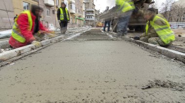 Beton karıştırıcı hızlandırıcı hiperhızlandırıcıyla yolu açmak için çelik takviyesi yaptıktan sonra hazır beton döküp düzleştiriyorlar. Tramvay raylarının yeniden inşası