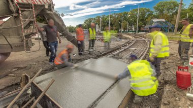 Beton işleri ve yol inşaatı için bir sürü işçi ve mikser hızlandırıcı ile aynı seviyeye gelmek. Metal takviyesine harç dökülüyor. Tramvay raylarının yeniden inşası