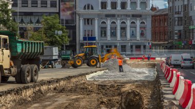 Endüstriyel kazıcı toprağı hareket ettiriyor ve taşları eziyor. Tramvay raylarının yeniden inşası