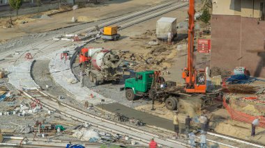 Beton, yol yapımında üniformalı, karıştırıcı makineli ve vinçli birçok işçiyle çalışıyor. Tramvay raylarının yeniden inşası