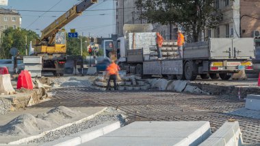 Yükleme ve boşaltma için vinç, geniş bir yükleme platformuyla birlikte büyük boy kamyondan takviye olarak havadan zaman ayarlı bir inşaat sahasında duruyor.