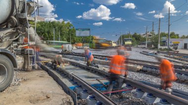 Çelik takviyesinin içine beton karıştırıcı zaman ayarıyla yol yapmak için hazır beton dökülüyor. Tramvay raylarının yeniden inşası