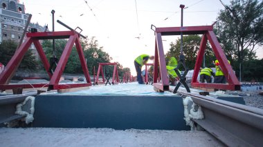 Kurulum aşamasındaki tramvay rayları ve yoldaki beton plakalara entegrasyon. Titreşim ve gürültü için sıvı reçineyle doldurulmuş. Tramvay raylarının yeniden inşası