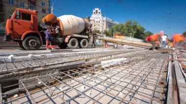 Beton yol yapımında çok sayıda işçi ve mikser zaman aşımına yol açar. Metal şebeke takviyesine havan topu dökülüyor. Tramvay raylarının yeniden inşası