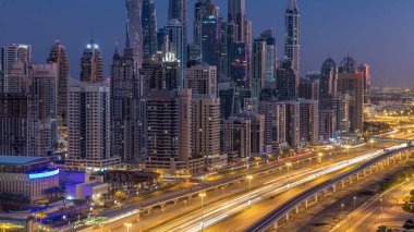 Dubai Yat Limanı gökdelenler hava üstten görünüm güneş doğmadan önce Jlt gelen Dubai gece gün timelapse, Birleşik Arap Emirlikleri için. Işıklı modern kuleleri ve Şeyh zayed yolu üzerinde trafik.