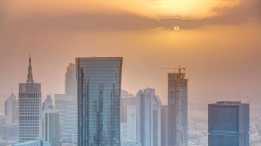 Günbatımında gökdelenler başkent Katar 'ın ticaret merkezi Doha' nın ufuk çizgisinde. Sisli havada hava manzarası. Bulutlu turuncu gökyüzü