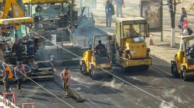 Yeni yol inşaatında çalışan yol silindirlerinin geniş bir manzarası var. Görünümü asfaltlama çalışmaları ile kapat