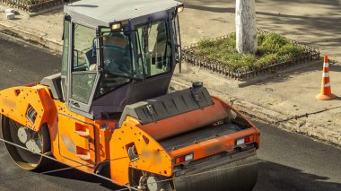 Yeni yol inşaatında çalışan yol silindirlerinin geniş bir manzarası var. Görünümü asfaltlama çalışmaları ile kapat