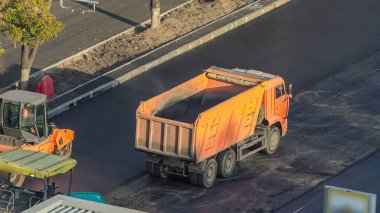 Yol yapımı ve tamirat sırasında asfalt kaldırım makineleri ve bahşiş veren işçiler. Üst görünüm