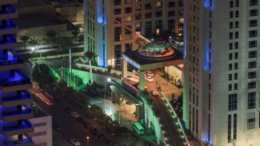 Gökdelenlere gece görüşü ve Dubai Marina 'daki trafik saatleriyle köprü. Yanan kuleler, geçitten geçen arabalar.