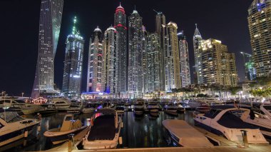 Dubai Marina 'nın en yüksek gökdelenleri, konut kuleleri ve tekneleriyle liman gecesi Dubai, Birleşik Arap Emirlikleri' nde hiper hız.
