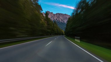 Avusturya, bir güzel sonbahar günü timelapse hyperlapse drivelapse Alpler'de asfalt yolda sürücü. Orman ve dağlar akşam