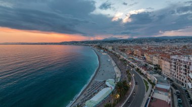 Panorama over Nice city and Mediterranean Sea aerial day to night transition timelapse. Bay of Angels with dramatic sky from Castle viewpoint, Cote d'Azur, French Riviera, France clipart