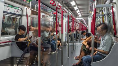 Metro treninin içi zaman ayarlı, istasyona fayton yolculuğu, tren pencerelerinde yanıp sönen açık hava ışıkları. Oturan ve çıkmaya hazırlanan yolcular. Trenin içinde perspektif.