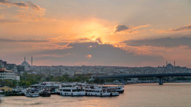 İstanbul 'un ufuk çizgisi İstanbul' da, günbatımında Boğaziçi ve Altın Boynuz 'daki tekne istasyonu yakınlarında çok sayıda yolcu feribotu bulunuyor. Arka planda cami ve köprü, bahar akşamında suyun yansımasıyla