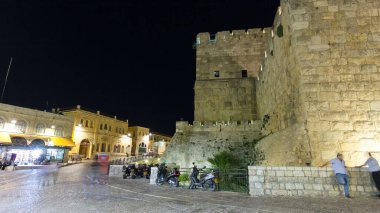 David 'in Kulesi gece hızlandırılmış hiperhız. İsrail 'in Kudüs kentindeki eski şehrin duvarları aydınlandı. Sokakta yürüyen insanlar