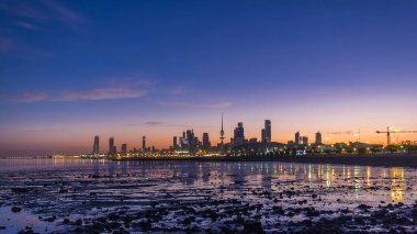 Seaside skyline of Kuwait city from night to day transition timelapse. Modern illuminated towers and skyscrapers reflected in water. clipart