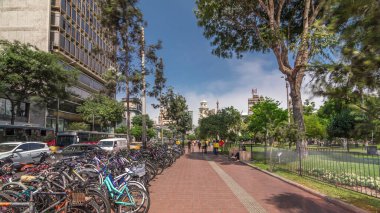 Jose Larco Bulvarı 'nda kırmızı bisiklet pisti ve Miraflores, Lima Peru' da bisiklet parkında hız sınırı. Central Park sağda ve caddede trafik var.