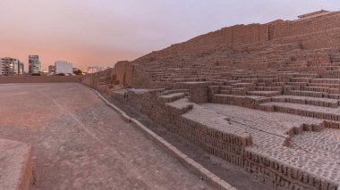 Pyramid of Huaca Pucllana day to night transition timelapse, pre Inca culture ceremonial building ruins in Lima, Peru. Clouds on a sky. Illumination is turning on clipart