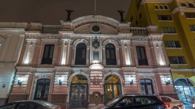 Merkez Postane Binası gece saatlerinde aydınlandı. Hipersürat, 1897 'de açıldı. Tarihi bina ve cadde trafiği. Lima, Peru