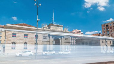 Old Porta Garibaldi monument arch timelapse hyperlapse and modern buildings of Porta Garibaldi, in Milan. Traffic on the road. Blue cloudy sky at summer day clipart