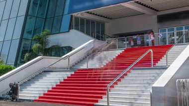 Fransa 'nın Cannes kentindeki Palais des Festivals et des Congres' in kırmızı halı merdivenlerinde. Güneşli bir yaz günü. Film çeken turistler