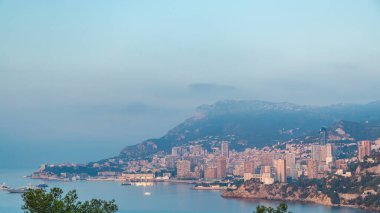 Monte Carlo 'nun şehir manzarası. Sabah sıcacık ışıklarıyla yaz gündoğumunda Monako' da. Sabah sisi ve bulutlar. Limandaki yatlar. Kaptan Martin 'den üst görünüm