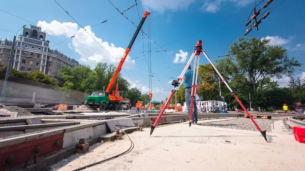 Tramvay rayları onarılan ve hiperhızlandırılmış yol inşaatı. Kavşağın ortasındaki tripodun elektronik seviyesi. Yeni toplu taşıma için demiryolu raylarının değiştirilmesi