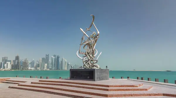 stock image Calligraphy sculpture on the Corniche of Doha timelapse hyperlapse, Qatar. Skyscrapers of west bay on background