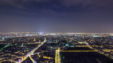 Şehir geceleri gökyüzünden gökyüzüne yükseliyor. Paris, Fransa. Turun hava görüntüsü Montparnasse panoramik zaman dilimi ve caddelerde trafik