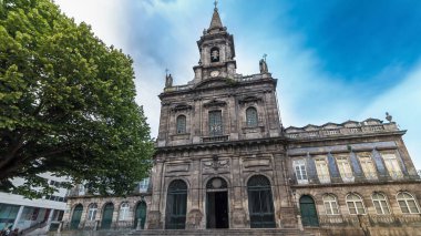 The Trinity Church front view timelapse hyperlapse with cloudy sky and fountain on square in Porto, Portugal. Porto is one of the most popular tourist destinations in Europe.