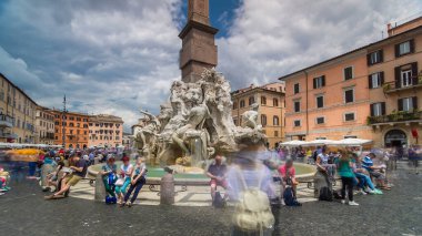 Piazza Navona, the fountain of four rivers timelapse hyperlapse. People sitting around. Cloudy sky. Italy, Rome