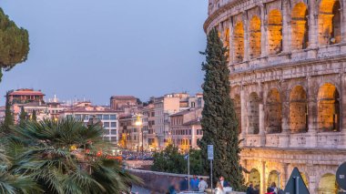 Gün batımından sonra Kolezyum 'dan geceye geçiş, Roma. Akşam aydınlatması. Yollarda trafik vardı. Roma en iyi bilinen mimari ve dönüm noktası. Roma Kolezyumu, Roma ve İtalya 'nın başlıca ilgi alanlarından biri.