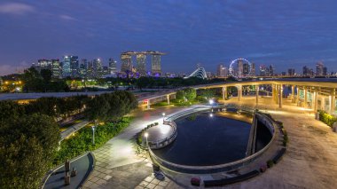 Panorama of Singapore with Gardens by the bay and cloud forest, flower dome and supertrees night to day transition timelapse before sunrise. Top view from marina barrage