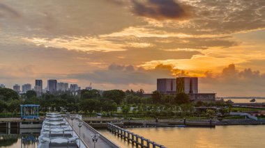Marina Barrage 'da güzel bir gün doğumu zamanı. Turuncu gökyüzü ve güneş ışınlı bulutlar. Singapur 'un 15. su deposu ve şehrin göbeğindeki ilk su deposudur..