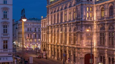Avusturya, Viyana 'daki Wiener Staatsoper (Viyana Devlet Operası) hava gününden geceye geçiş zamanının güzel manzarası. Tarihi binalar ve caddelerdeki trafik aydınlandı