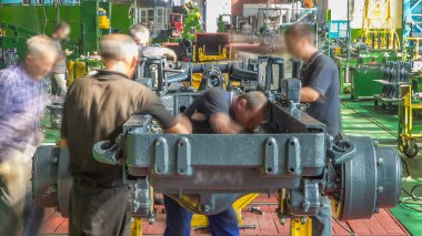 Konveyör montajı, traktörün gövdesini büyük endüstriyel fabrika zaman diliminde sahneleyecek. Çerçeve montajı, Chassis kurulumu ve diğer bölümler etrafındaki işçiler.