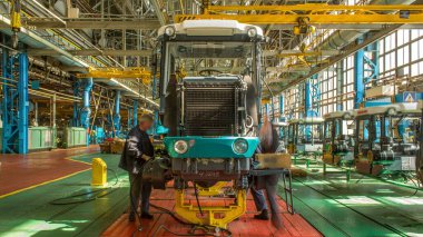 Konveyör montajı, traktörün gövdesini büyük endüstriyel fabrika zaman diliminde sahneleyecek. Çerçeve montajı, radyatör ve kabin kurulumu ve diğer parçaları olan motor.