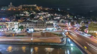 Georgia 'nın Tiflis şehrinde ahşap oymalı balkonları olan renkli geleneksel evler. Aydınlatılmış binalar ve trafik