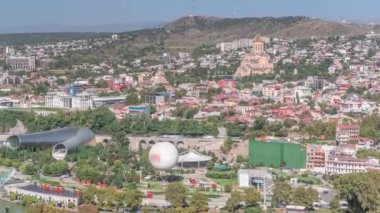 Kutsal Tiflis Trinity Katedrali, Gürcistan Seremoni Sarayı ve Rike Park 'taki konser salonu. Tiflis, Georgia. Arka plandaki evler ve yoldaki trafik