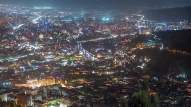 Rike Park 'ın olduğu şehir panoraması gece yukarıdan. Tiflis 'in eski bir kasabasındaki modern şehir parkı. Tarihi ve modern binalarla aydınlatılmış Barış Köprüsü ve hava balonu. Georgia