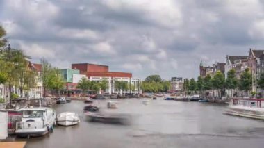 Ulusal Opera Müziği ve Tiyatro Salonu 'nun dış cephesinin aşırı hızlanması. Amsterdam 'daki nehirde, bulutlu bir gökyüzünün altında yüzen yüzen evler. Hollanda 'daki popüler turizm beldesi