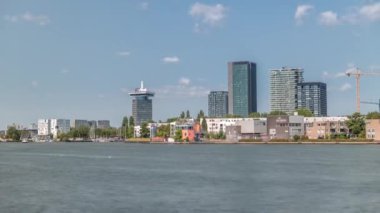 Amsterdam 'ın en modaya uygun modern kulelerinin zaman çizelgesi. Şehir merkezinde Hey seti üzerinde, Göz Film Müzesi' nin yanında. Mavi gökyüzünün altında bir feribot nehri geçer. Hollanda