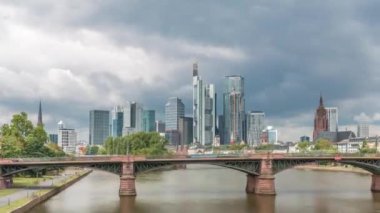 Frankfurt 'un, ana nehir ve Ignatz Bubis Köprüsü' yle olan hiperhızlandırılmış silueti. Gökdelenler ve kilise kuleleri dramatik bulutların altındaki suya yansıyor. Frankfurt, Almanya