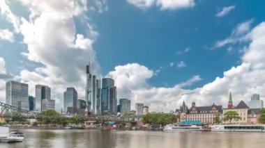 Almanya 'nın Frankfurt kentindeki ana nehir üzerindeki tarihi Eiserner Steg Demir Köprüsü' nün hızlandırılması. Gökdelenler ufuk çizgisi ve tarihi binalar bulutlarla dolu bir zaman dilimi altında suya yansıyor.