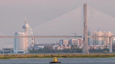 Lizbon 'da Tagus nehri üzerindeki Vasco da Gama Köprüsü' nün üzerinde Milletler Parkı, modern mimari, Portekiz. Yeni açılan Percurso Ribeirinho de Loures yürüyüş yolundan gün batımı manzarası